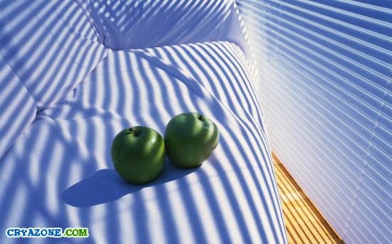 Два зелёных яблока на белом диване